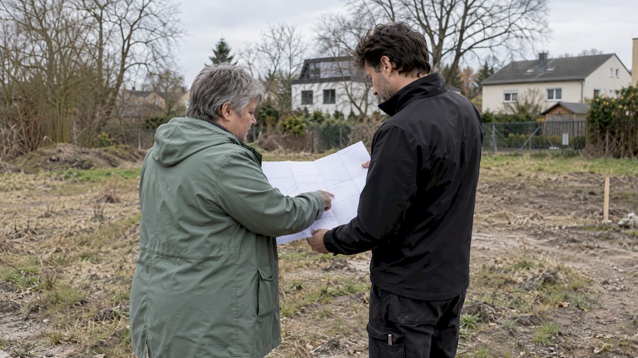 Die Eigentümerin und der Architekt betrachten gemeinsam einen Lageplan